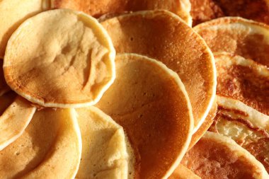 İçi narenciye meyvesi dolu bir krep yığını masanın üzerinde duruyor. Doğal ürünlerden yapılan lezzetli bir yemek.