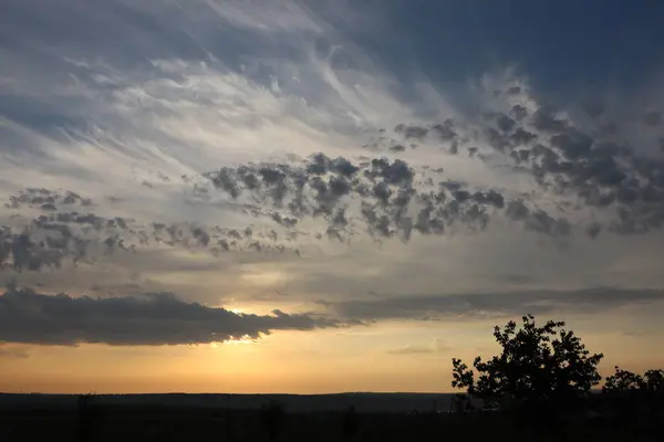 Stock image Evening sky over serene rural landscape shows stunning sunset with amazing clouds, creating beautiful peaceful scene