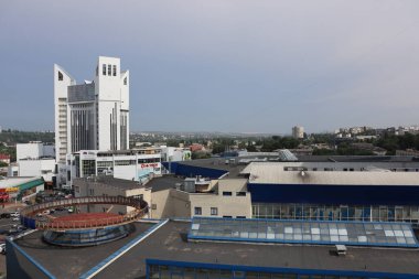 Ayırt edici bir kule, çeşitli binalar ve kentsel altyapıya sahip modern bir şehir manzarası.