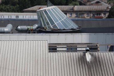 Modern şehir mimarisini gösteren cam yapı ve havalandırma borularıyla sanayi binalarının çatısı kapanıyor.