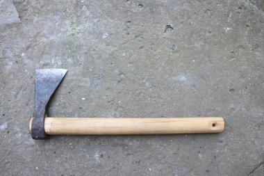 Ahşap saplı eski bir balta beton yayar. Klasik cazibe yayar. Yılların kullanımı ve tarihi sergilenir.