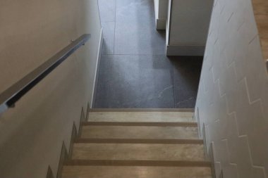 Bu modern merdiven, zıt karanlık ve aydınlık fayanslara sahip bir koridora çıkan ışık adımlarını içeriyor..