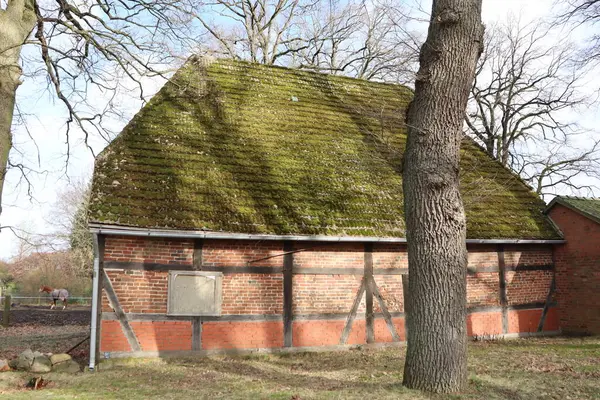 stock image A mosscovered barn in a serene countryside, perfect for rustic architecture and nature scenes