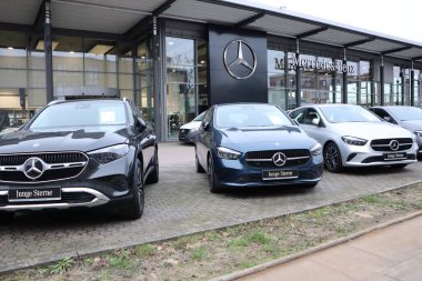 Yeni, lüks MercedesBenz araçları bir galeride sergileniyor, otomotiv tasarımında zarafet ve yenilik vurgulanıyor