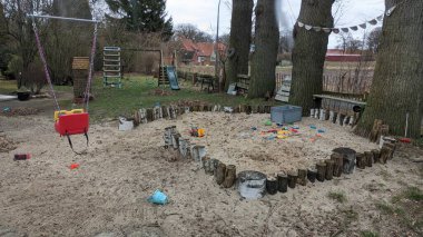 Ormanın ortasında, etrafını saran ağaçlar ve canlı otlarla çevrili hoş bir kum havuzu var.