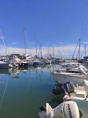 Çok güzel bir marina, sakin suları yansıtan çeşitli teknelerle doludur.