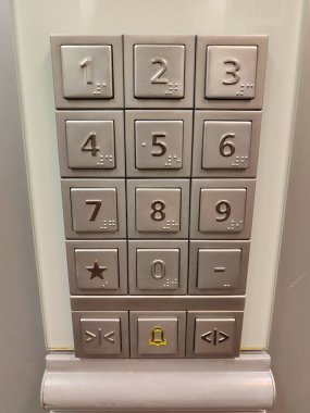 Gelişmiş kullanım kolaylığı için rakamlar, bir yıldız sembolü ve yön okları içeren çağdaş bir asansör tuş takımı