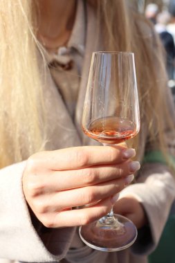 Zarif bir kadın elinde bir kadeh şarap tutarak eğlencenin özünü yakalıyor.