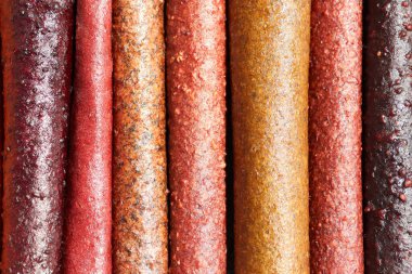 Meyve ezmesinden yapılmış çok renkli tabaklar bu canlı ve renkli meyve dürümleri sağlıklı bir atıştırmalık olarak yemek ve doğal tatlılık sunmak için mükemmeldir.