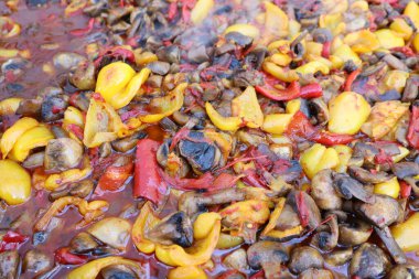 Lezzetli ve lezzetli bir sosta kaynayan çeşitli biberler ve taze mantarların canlı ve renkli bir karışımı.