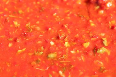 Taze otlar ve baharatlarla zenginleştirilmiş lezzetli domates sosu yakın plan. Lezzetli yemekleri geliştirmek için mükemmel.