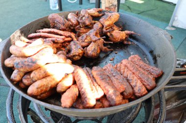 Izgara sosis ve mangal tepsisinde nefis cızırdayan çeşitli etlerden oluşan baştan çıkarıcı ve canlı bir karışım.