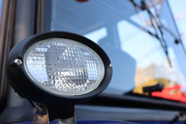 Bu, yenilikçi tasarımı ve pratik işlevselliğini gözler önüne seren bir traktör farının detaylı bir yakın çekimi.