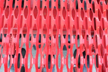 Canlı kırmızı bir ağ yüzeyinin yakın çekim görüntüsü güzel bir şekilde karmaşık ve eşsiz geometrik desenleri gösteriyor.