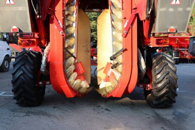 A detailed closeup view of an advanced agricultural harvester equipped with dual cutting blades actively in operation clipart