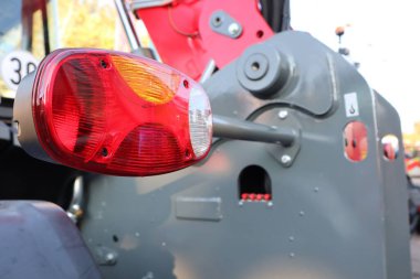 Bir traktörün yakın plan görüntüsü, işlevselliğinin yanı sıra karmaşık tasarımını da güzel bir şekilde gösteren kuyruk lambası.