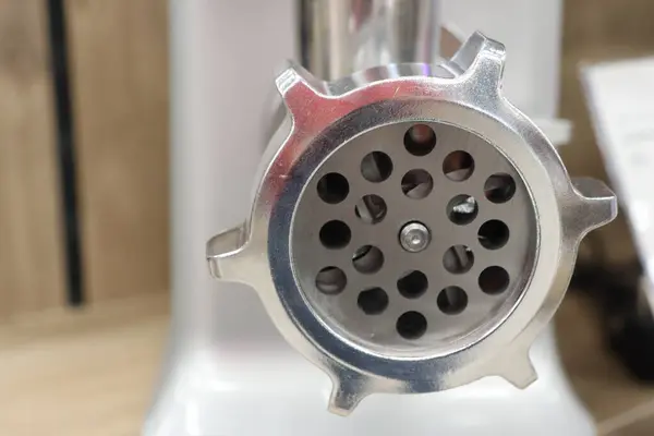 Bu, kıyma makinesi için iyi işlenmiş metal bir eklentinin yakın çekim görüntüsü. Ev yemeği meraklıları için ideal.