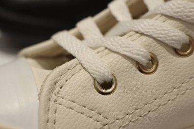 Beyaz spor ayakkabısı, gösterişli bağcıklar ve pirinçten gözler. Moda ve atletik temalar için mükemmel..