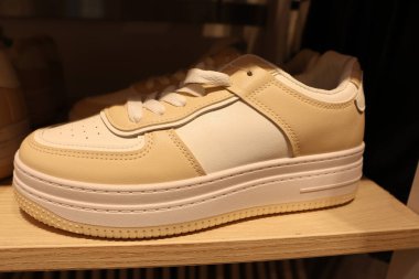 Havalı bir platform tabanlı bej renkli spor ayakkabılar, günlük kıyafetleri ve modern moda tarzlarını geliştirmek için ideal.
