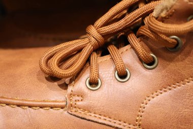 Moda ve ayakkabı temaları için ideal kahverengi deri çizme bağcıkları ve göz eletleri..