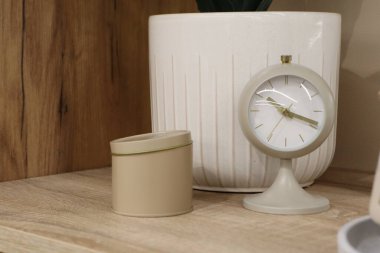 Şık bir saat ve krema kabı sıcak, davetkar bir dekor oluşturarak estetik açıdan memnun edici bir atmosfer yaratır.