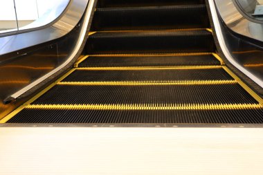 Çağdaş tasarım, estetik ve işlevselliği güzel vurgulayan yürüyen merdiven adımlarının yakın görüntüsü