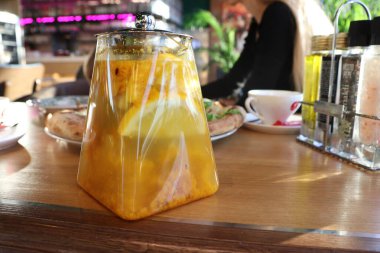 Limon dilimli ferahlatıcı bir içecek, şık bir kafede zarif bir şekilde servis edilir, canlı bir atmosfer yakalar.