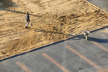 İnşaat alanındaki işçiler bölgeyi yaklaşan kalkınma faaliyetleri için dikkatlice hazırlıyorlar.