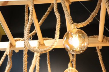 Bu nefis ve eşsiz kolye lambası doğal halatı büyüleyici ahşap kirişlerle güzelce birbirine bağlıyor.