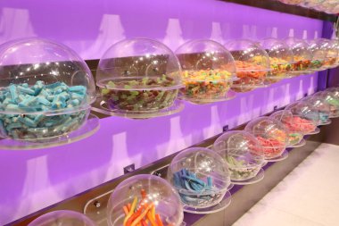 Cam kavanozlardaki renkli şekerlemelerden oluşan canlı bir seçim, her durumda tatlı arzuları tatmin etmek için ideal.