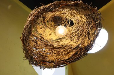 Günümüz dekorasyonunu geliştirmek için ideal, rahat bir kuş yuvasına benzeyen güzel, yaratıcı bir aydınlatma armatürü.