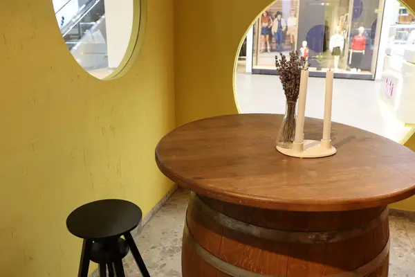 Tahta bir varil masası, tabure ve dekoratif mumlar içeren büyüleyici bir kafe.