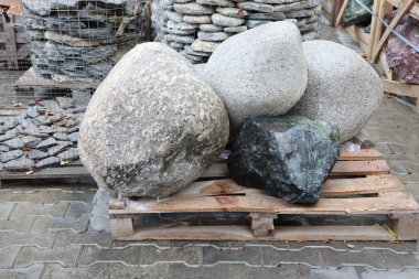 Pürüzsüz, doğal taşların dikkatlice bir paletin üzerine istiflenmiş, peyzaj ve ev dekorasyonu için mükemmel bir koleksiyon.