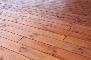 Bu, güzel cilalanmış ahşap döşeme tahtalarının zengin, sıcak bir tonu ve dokusunu gösteren yakın çekim görüntüsü.