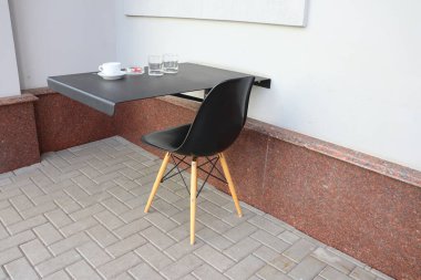 Şık, şık bir iç dekorasyonda çağdaş bir sandalyeyle birleştirilmiş duvar montajlı bir masa.