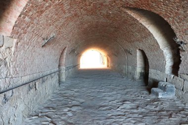 Nefes kesen güzel bir tuğla kemer yolu koridoru parlak bir ışığa doğru uzanan zarif taş döşemeleri barındırır.