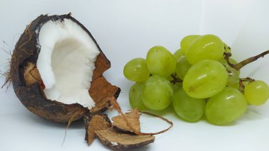 A vibrant display of a cracked coconut and fresh green grapes perfect for healthy lifestyle visuals. clipart