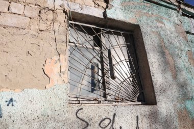 Bu, paslı parmaklıkların bulunduğu terk edilmiş bir binada bulunan çok harap ve ihmal edilmiş bir pencerenin yakın çekim görüntüsü.