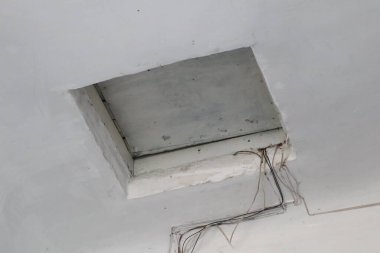 Henüz tamamlanmamış ya da tamamlanmamış bir alandaki kabloları gösteren açıkta kalmış bir tavan erişim noktası