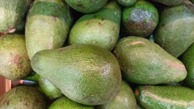 Yerel bir markette canlı ve cezbedici bir yeşil avokado gösterisi. Tüm sağlıklı yemekler için mükemmel.