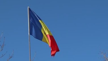 Moldova bayrağının canlı ve renkli bir görüntüsü berrak mavi gökyüzünün altında zarif bir rüzgarda dalgalanıyor.