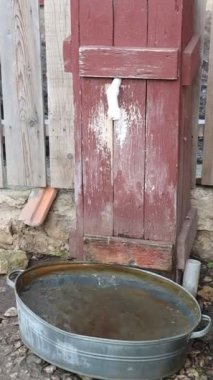 Kırsal alanda metal bir havzası olan klasik bir su kuyusu. Geleneksel su koleksiyonu sergileniyor..