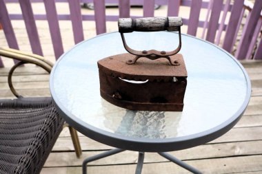 Güzel bir klasik demir, kırsal güzelliğini ve derin nostaljisini yansıtan yansıtıcı bir masanın üzerinde zarif bir şekilde durur.