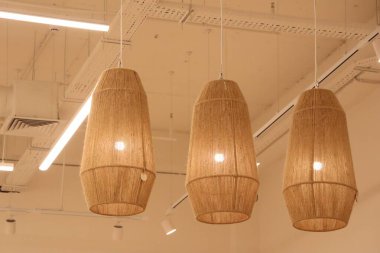 Örülmüş kolye ışıkları modern yaşam alanlarının genel estetiğini ve sıcak havasını önemli ölçüde artırır.