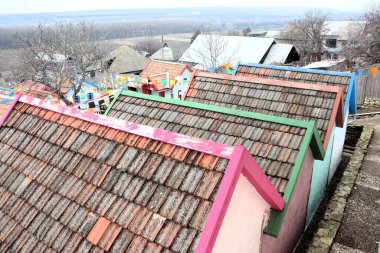 Vibrant rooftops of uniquely designed houses showcase colorful architecture in a peaceful, tranquil setting clipart