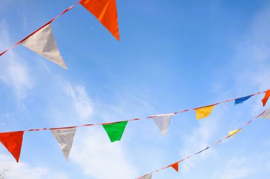 Canlı ve renkli bayraklar bugün açık mavi bir gökyüzünün altında ılık yaz esintisinde yavaşça dalgalanıyor.