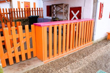 A vibrant orange fence beautifully highlights a unique outdoor space that is adorned with colorful accents clipart