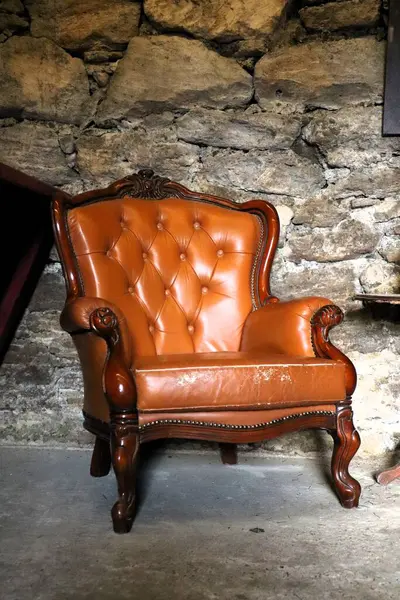 Nefis bir klasik deri koltuk. Zarifçe yerleştirilmiş. Büyüleyici bir taş duvar zeminine.