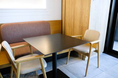 Zarif kafe, minimalist estetiğe sahip rahat bir oturma alanı içeren güzel tasarlanmış bir iç mekan içeriyor.