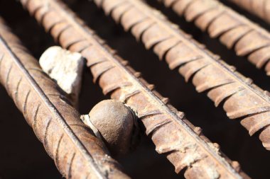 Küçük taşlarla paslı demiri gösteren bir detay, eşsiz dokuyu ve endüstriyel özellikleri vurguluyor